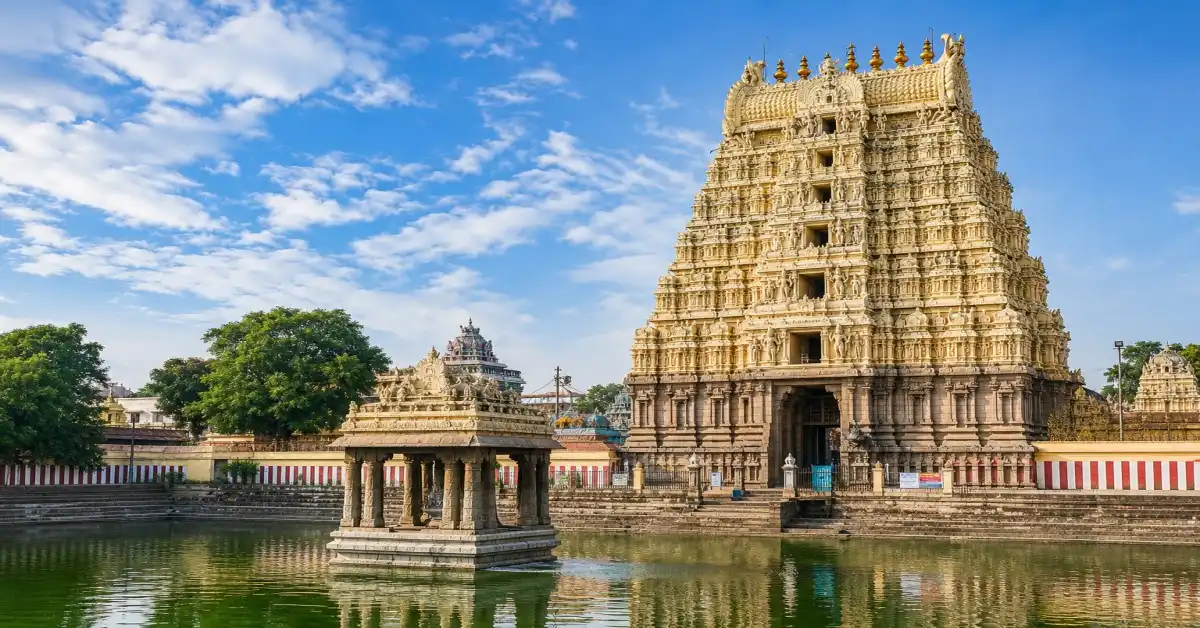 Kanchipuram temple with a beautifully carved gopuram and sacred temple tank under a blue sky